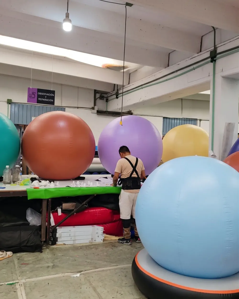 Trabajador en el taller entre pelotas inflables de colores